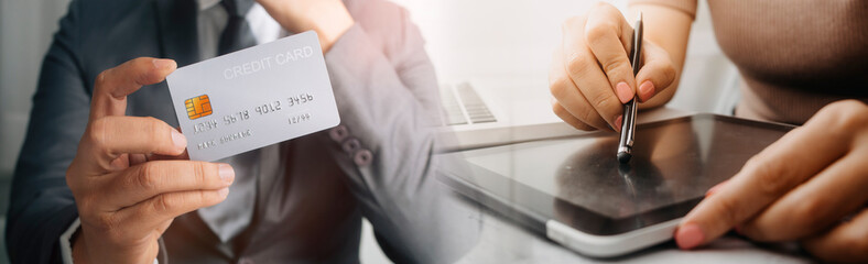 businesswoman hand using smart phone, tablet payments and holding credit card online shopping, omni channel, digital tablet docking keyboard computer at office in sun light