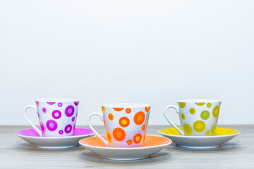 A set of cups. Dishes for coffee. There are three coffee cups and saucers on the table.