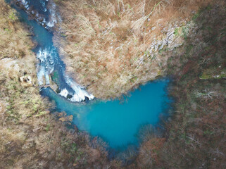 Aerial shot of beautiful Sluncica river wll, hidden deep in the  mountain forest with stone cascades in the river stream