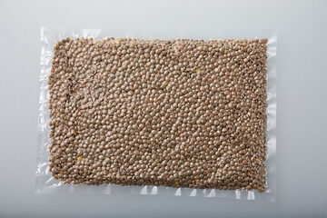 Fresh lentils in vacuum sealed plastic bag on white background