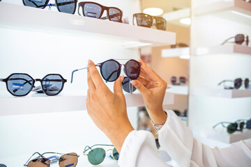 Row of glasses at an opticians. Eyeglasses shop. Stand with glasses in the store of optics. Woman's...