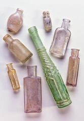 A collection of vintage bottles lying on a white background