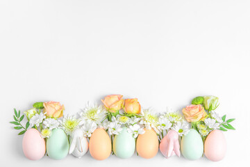 Creative layout composition of flowers and easter eggs on pastel background.