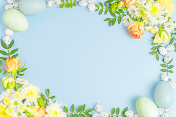 Creative layout composition of flowers and easter eggs on pastel background.
