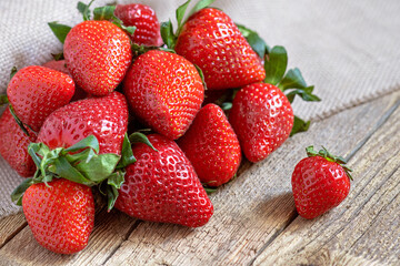 red ripe large strawberries on an old wooden table, rustic style, vitamins in berries, healthy and tasty food