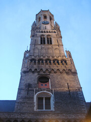 Obraz premium bell tower of the cathedral. Gothic cathedral country. Evening city view of the Belgian medieval old town. Scenic landscape with beautiful ancient brick building on a cold spring day.