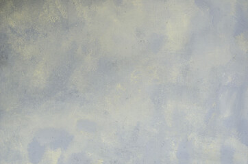 Abstract textured gray-yellow background on a cloth base.