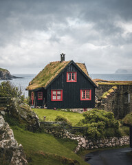 Fototapeta na wymiar Kirkjuboargardur, also called Roykstovan, is a historic farm and museum in Kirkjubour, Faroe Islands. Built in the 11th century it is one of the oldest still inhabited wooden houses of the world.