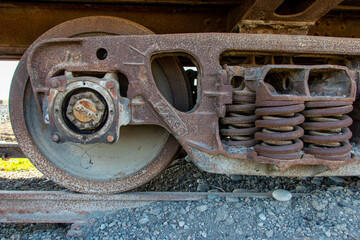 Fragment of old rusty railway carrige, including chassis and wheels on rails. Made in USSR