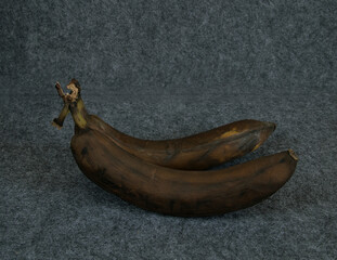 Two overripe bananas on a dark background.