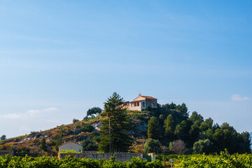 Fototapeta premium Small church of San Miquel, on a small hill surrounded by orange groves and country houses, in La Font d'En Carròs (Valencia, Spain)