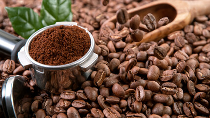 Falling Roasted Coffee Beans on Brown Background, close-up.
