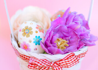 white Easter eggs and flowers in basket on pink background, a minimal creative concept of a happy Easter