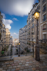 Obraz premium Paris, France - 02 26 2021: Montmartre district. Stone staircase with illuminated lanterns