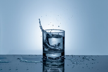 Splash of water in a glass. Splashing water. Ice water. Concept. High quality photo