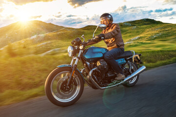 Fototapeta na wymiar Moto racer riding on forest road during sunset, blurred motion.