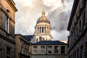 Nottingham city centre skyline with council house dome roof old buildings with sunshine and clouds lit up with golden hour light