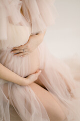 pregnant girl in a boudoir dress stroking the baby in the belly