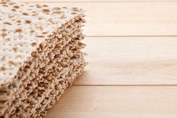 Jewish matzah on wooden rustic background. Jewish traditional Passover bread. Pesach celebration symbol. Close-up