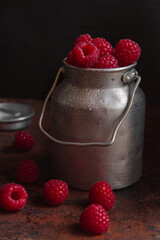 Aluminum can with fresh ripe raspberries on a darck background - 419720850