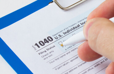 Filling out Tax Form 1040. Tax form and pen