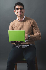 young man studying holding a laptop in a photo studio