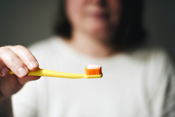 woman holding toothbrush and toothpaste