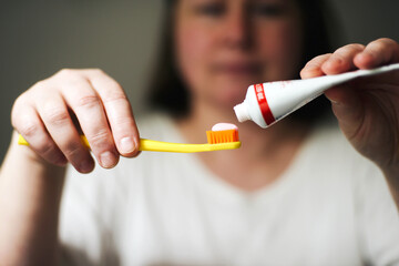  woman holding toothbrush and toothpaste
