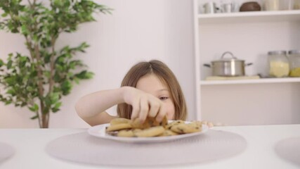 Glad little girl taking secretly cookie from the table, sweet dessert, sugar
