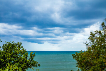 rain and large dark clouds over the sea, variety of shades of blue