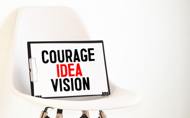 COURAGE IDEA VISION. Text on white notepad paper on light background.