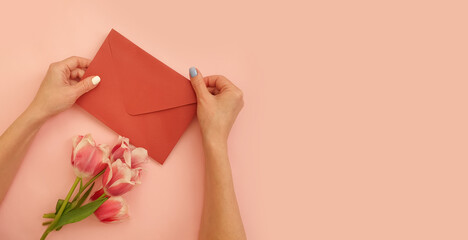 Obraz na płótnie Canvas female hands hold an envelope, a bouquet of tulips 