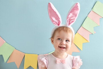 A cheerful girl with a smile in her rabbit ears. Easter holiday. A happy child.