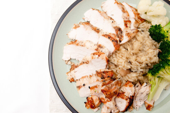 Top View Of A Tasty Dish With A Roasted Chicken Breast, Brown Rice, Broccoli, And Cauliflower