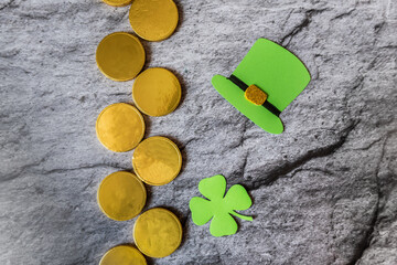line of gold coins, next to a maple leaf and a leprechaun's hat. green hat and maple leaf - handmade paper