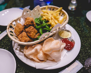 Snack basket with fried chicken, edamame green beans, french fries and dumplings