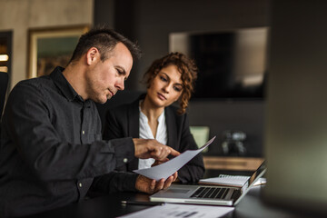 Dressed elegant, man explaining something to woman.