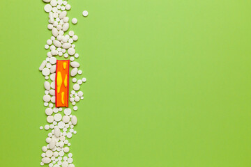 Treatment of atherosclerosis. Model organ lying on green background with pills. Copy space for text.