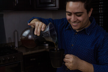 A happy man serves coffee in a black mug.
