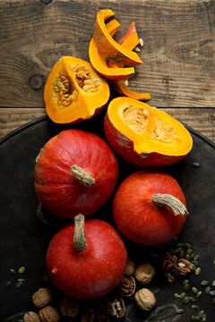 Walnuts and red kuri squashes on rustic baking sheet