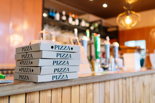 Stack of pizza boxes kept on counter at restaurant