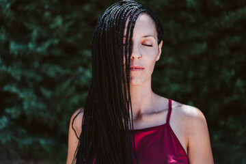 Woman standing with eyes closed outdoors