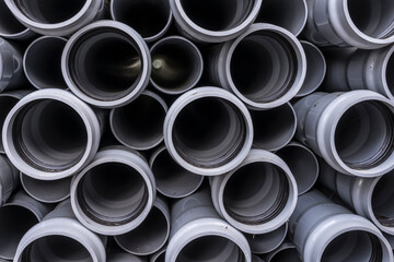 Stack of plastic pipes on a construction site.