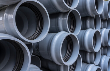 Stack of plastic pipes on a construction site.