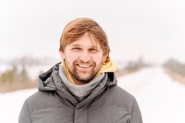 Close-up portrait of smiling mid adult man against clear sky during winter