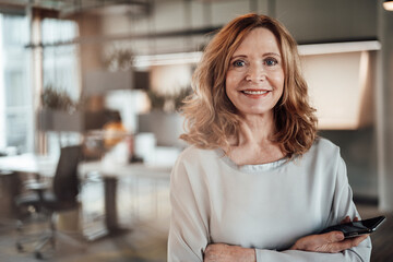 Elegant female entrepreneur with arms crossed in office