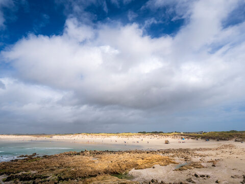 Beach against cloudy sky on sunny day