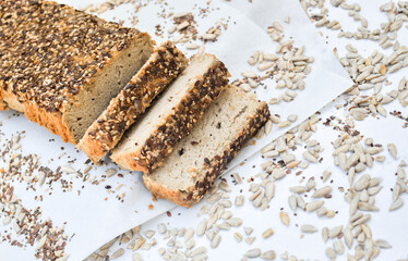Freshly cut keto bread on white background with seeds around