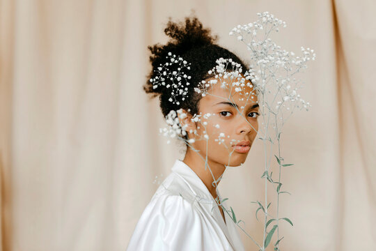 Young Woman With White Flowers In Front Of Face