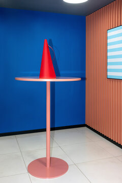 Red megaphone on table against blue wall at workplace